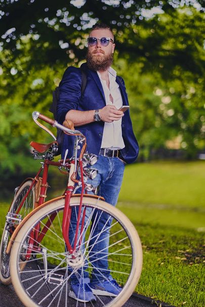 自転車とスマート フォンのひげを生やした男 - 写真・画像
