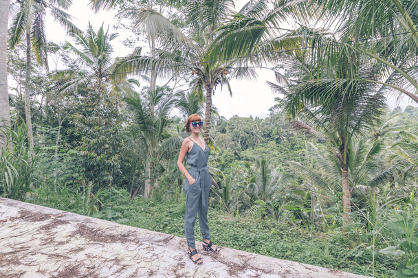 Jonge vrouw reiziger op de weg van de jungle, tropisch eiland Bali, Indonesië. - Foto, afbeelding