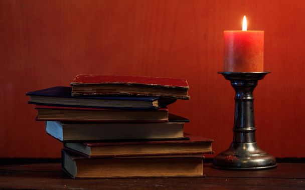 Винтажные книги и свечи на фоне доски
 - Фото, изображение