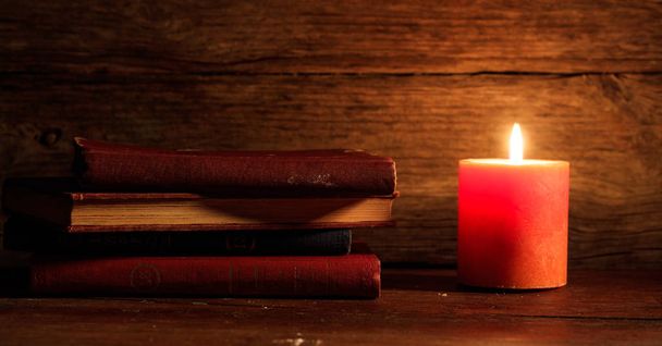 Винтажные книги и свеча на деревянном фоне
 - Фото, изображение