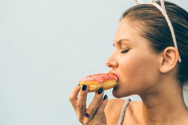 Sexy brunette lady eat sweet heart shaped donut. - Foto, Bild