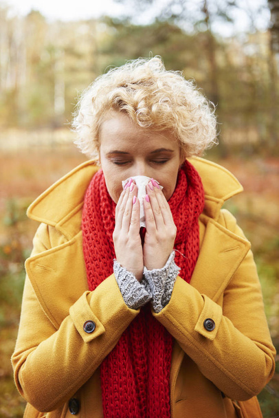 Imagen de una mujer estornuda con tejido en las manos
 - Foto, imagen
