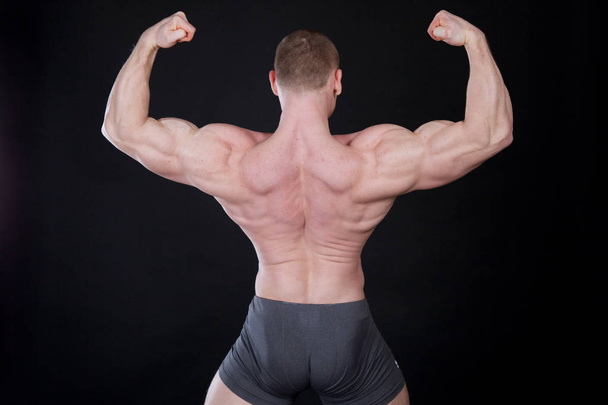 Sport the athlete bodybuilder shows off his muscles - Foto, afbeelding