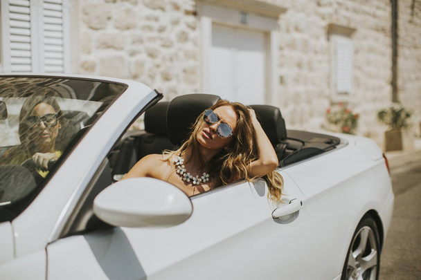 Young women in white cabriolet car - Photo, image
