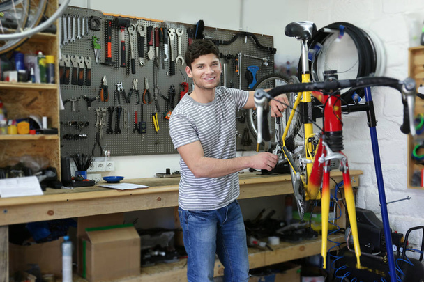 man working in bicycle repair shop - Foto, imagen