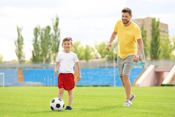 Dad and son playing football  - Фото, изображение