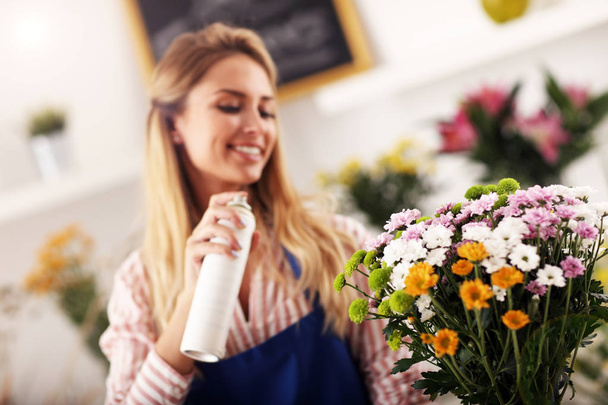 Vrouwelijke bloemist werkt in de bloemenwinkel - Foto, afbeelding
