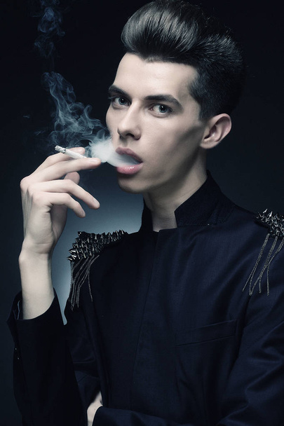 Young stylish man smoking a cigarette - Фото, изображение