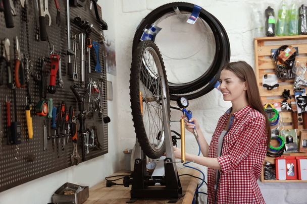 woman working in bicycle repair shop - Zdjęcie, obraz