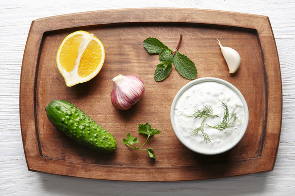 Delicious yogurt sauce in bowl with ingredients  - Foto, immagini