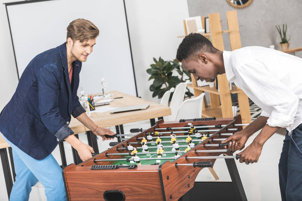 multicultural businessmen playing table football - Foto, afbeelding