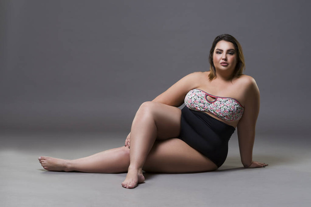 Plus size fashion model in sexy swimsuit, young fat woman on gray background, overweight female body - Foto, afbeelding