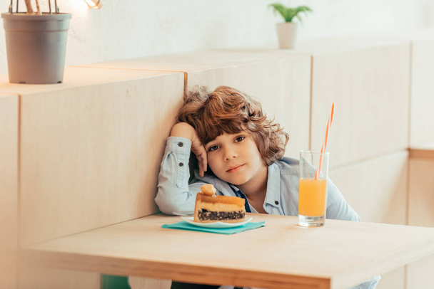 curly boy sitting in cafe  - Fotó, kép