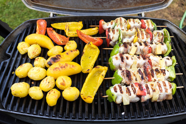 Assortiment de délicieuses viandes grillées avec des légumes sur les charbons sur
 - Photo, image