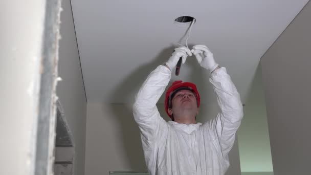 Eletricista instalando fios de cabos elétricos no teto do novo edifício
 - Filmagem, Vídeo
