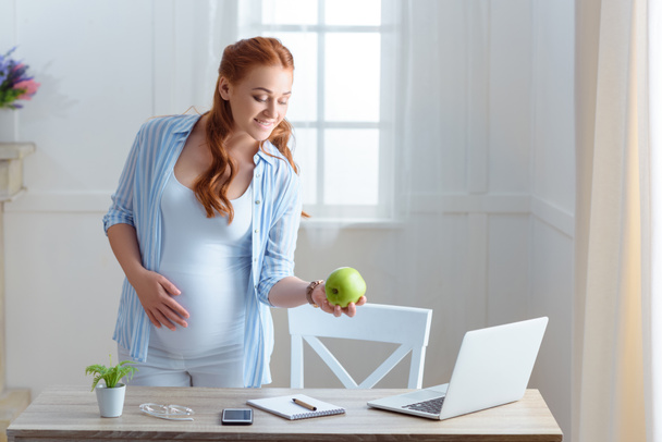 pregnant woman holding apple  - Fotografie, Obrázek