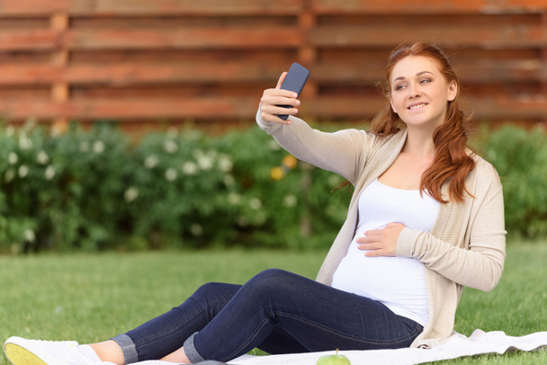 Mujer embarazada tomando selfie
  - Foto, Imagen