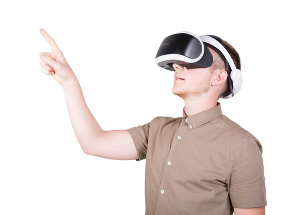 A young man is using a 3D virtual reality headset, isolated on a white background. New and professional audio equipment. A guy wearing virtual reality goggles. VR Glasses. - Foto, imagen