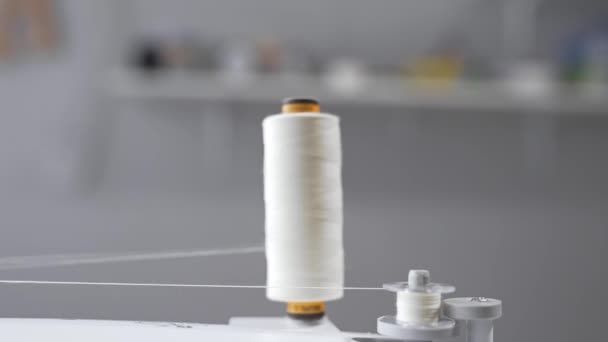 Thread is unwound from the reel during sewing, woolen thread and felt, clothing industry, process of handmade, sewing dresses and underwear - Footage, Video