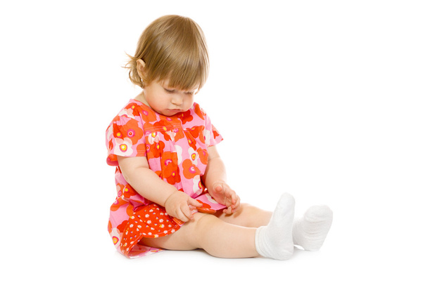 klein meisje in een rode jurk met speelgoed kop - Foto, afbeelding