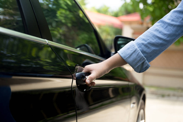 Γυναίκα χέρι, τραβώντας τη λαβή της πόρτας του αυτοκινήτου για να ανοίξετε το αυτοκίνητο  - Φωτογραφία, εικόνα