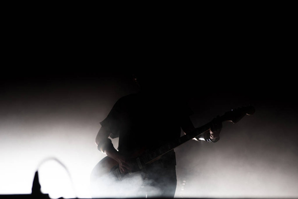 Silhouet van een gitarist op het podium - Foto, afbeelding
