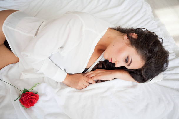 dziewczyny w bieliźnie leżąc na łóżku z różą - Zdjęcie, obraz