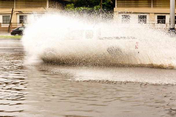 Autó vezetés elárasztó víz keresztül gyorsan az úton  - Fotó, kép
