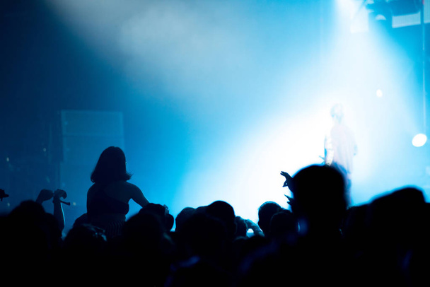 明るいステージライトの前のコンサート群集のシルエット - 写真・画像