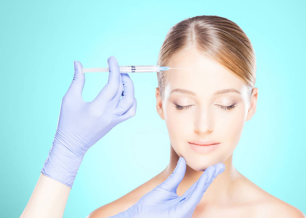 Doctor making injection into face of woman - Valokuva, kuva