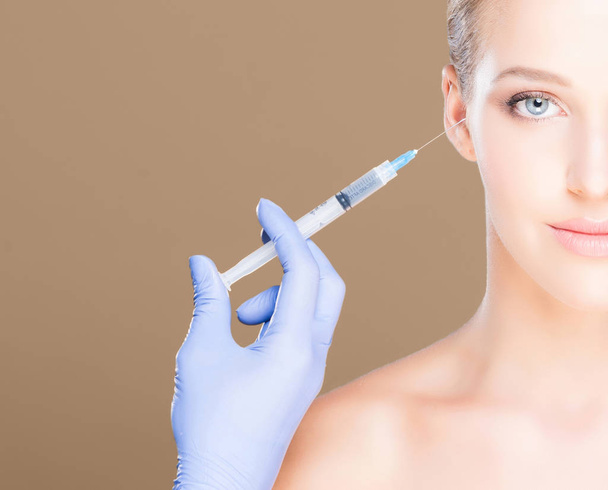 Doctor making injection into face of woman - Photo, Image