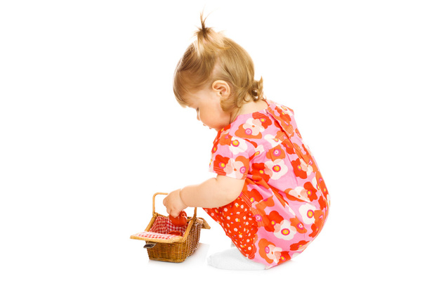 Small baby in red dress with toy basket - Foto, Imagem