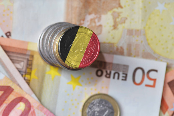 Moneta in euro con bandiera nazionale del Belgio sullo sfondo delle banconote in euro
 - Foto, immagini