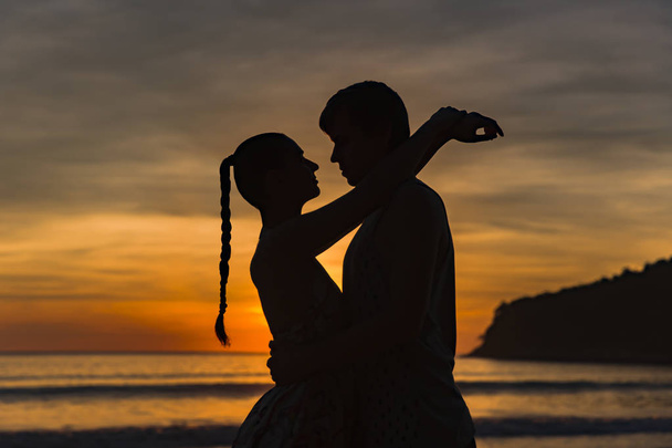 Romantic lovers hugging at twlilight with sunset in background - Photo, Image