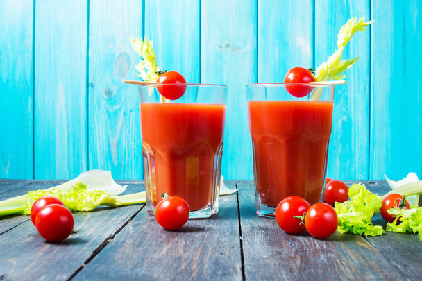 Tomato juice in glass with celery, cherry tomato on wood background - Photo, Image