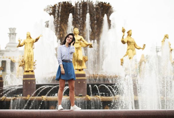 Young beautiful brunette girl posing near city fountain  - Fotografie, Obrázek