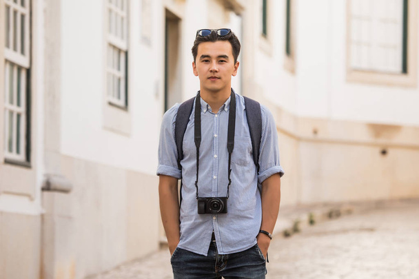 Portrait of man traveler in the old city with camera - Photo, Image