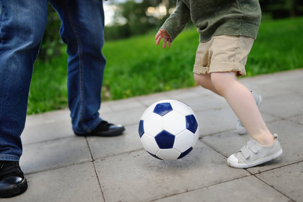 Little boy with his father having fun playing a soccer game on sunny summer day - 写真・画像