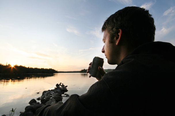 uomo con birra al lago
  - Foto, immagini