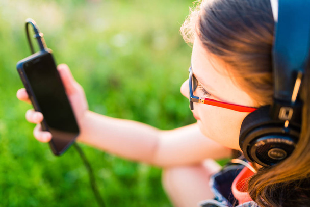 Tiener meisje, luisteren naar muziek met haar buiten koptelefoon - Foto, afbeelding