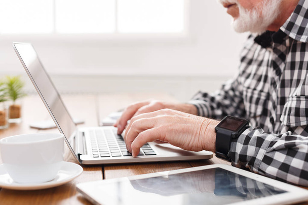 Senior man handen op laptop closeup - Foto, afbeelding