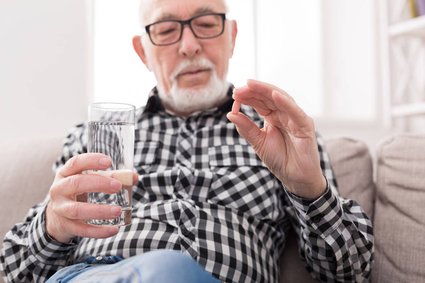 Stary człowiek w ręku o szklankę wody i tabletki - Zdjęcie, obraz