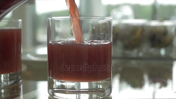 Pouring purple grape juice into a glass. Pouring fruit drink into a glass close up - Záběry, video