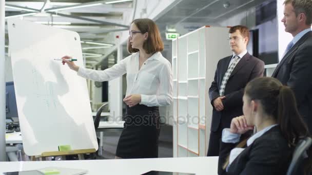 Bürokauffrau macht Präsentation auf Whiteboard für Kollegen. - Filmmaterial, Video