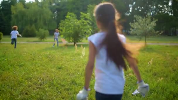 Jóvenes voluntarios enérgicos corriendo en el parque mientras limpian la basura allí
 - Imágenes, Vídeo