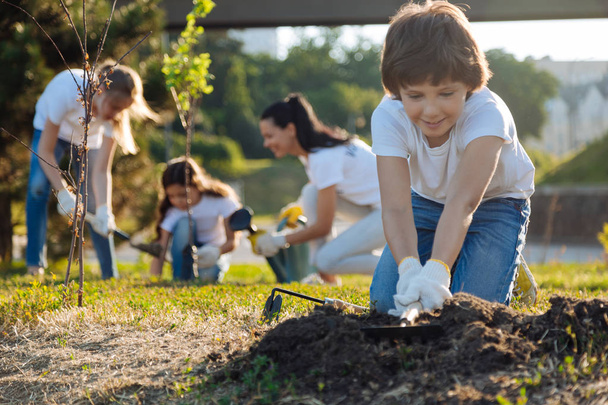 brunette kid preparing soil for usage - Zdjęcie, obraz