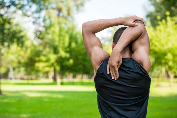 african american sportsman stretching in park  - Photo, Image