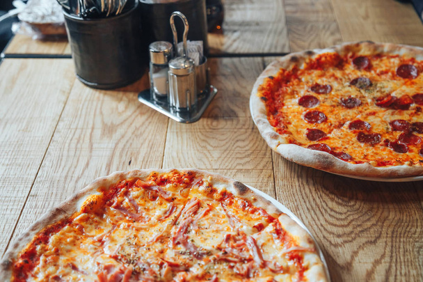 Two pizzas on wooden background - Φωτογραφία, εικόνα