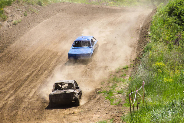 Old wrecked cars stock race. Racing in open air with dust - Photo, Image