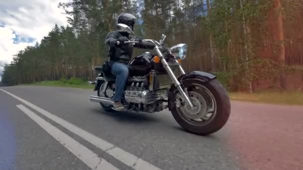 A motoros lovaglás egy motorkerékpár, viselt fekete ruhát és a bukósisak. - Felvétel, videó